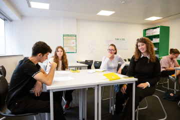 Students collaborating in a classroom discussion during a summer program